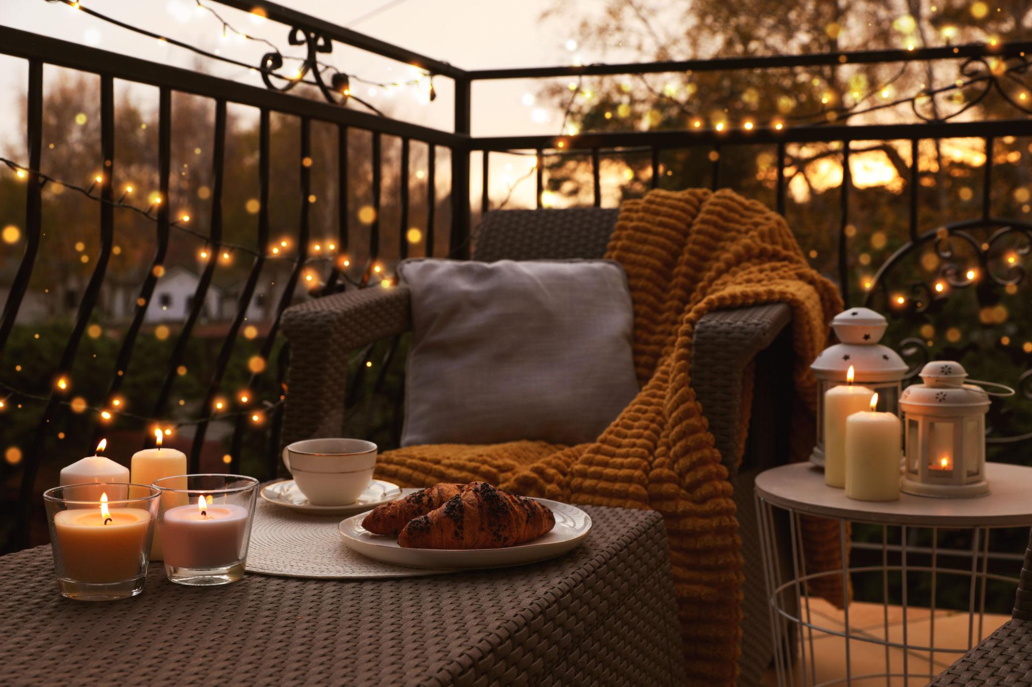 Cozy balcony seating with elegant furniture and warm lighting in a modern apartment.